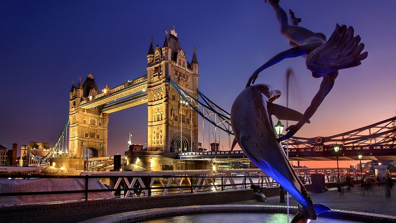 Tower Bridge med staty framfr mot en lilafrgad himmel i nattljus